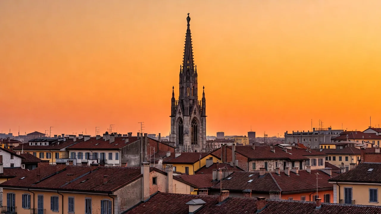 A gothic cathedral spire silhouetted against an orange sunset over Milan rooftops